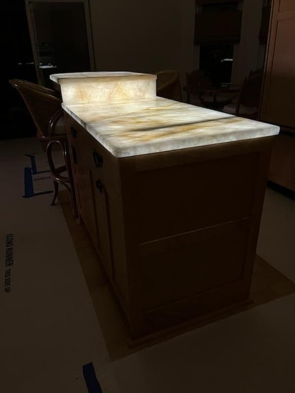 Backlit onyx kitchen island with unique patterns, showcasing modern design elements.