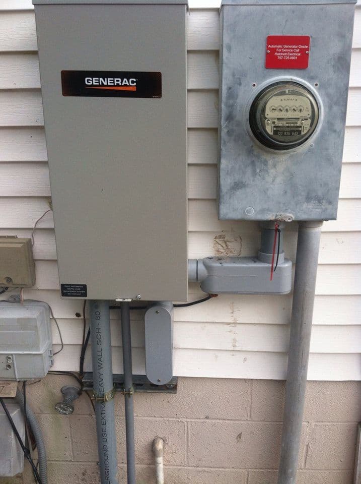 Generac generator installation with electrical meter and power connections on a house exterior.
