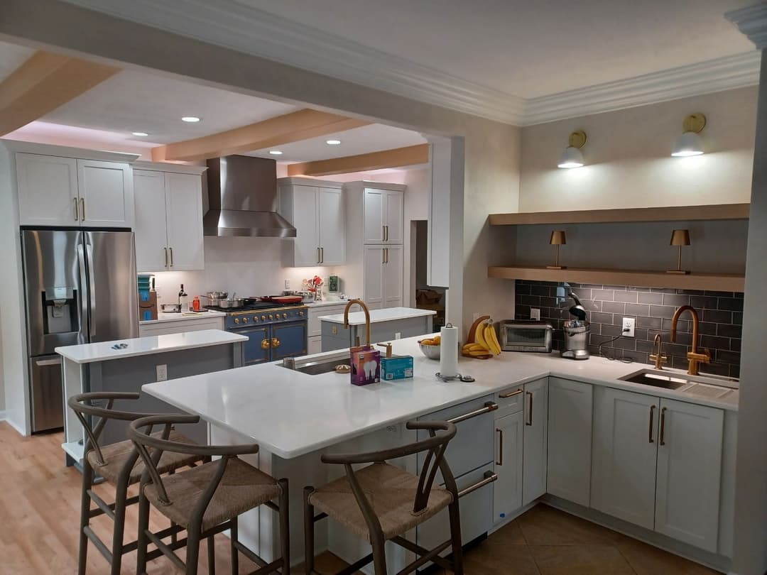 Modern kitchen with white cabinets, stainless steel appliances, and a spacious island.